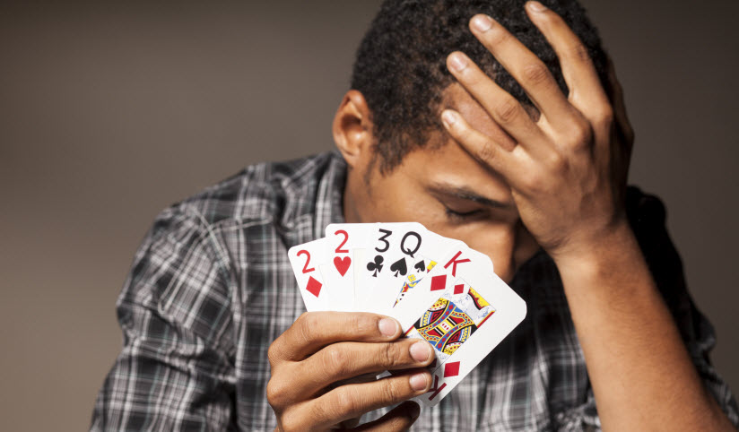 Man with gambling addiction holding cards