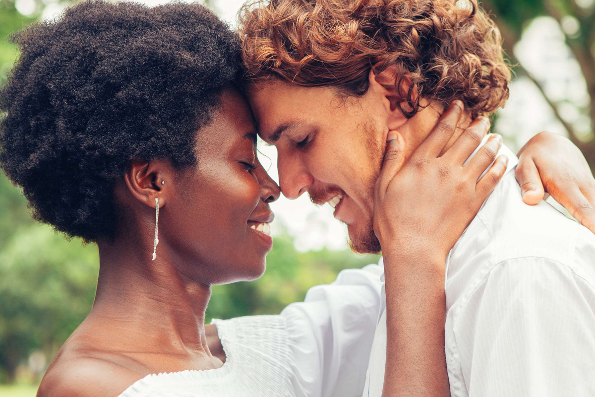 Biracial couple facing each other and smiling