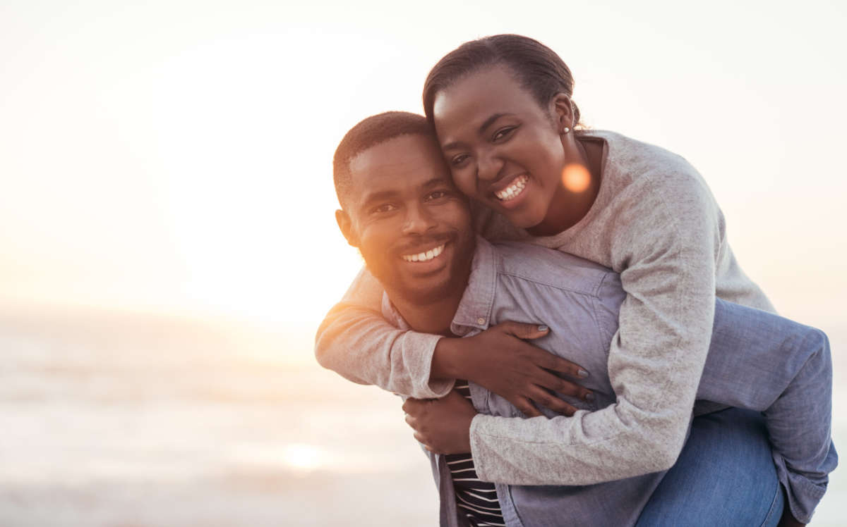 Young Black couple smiling in the sun