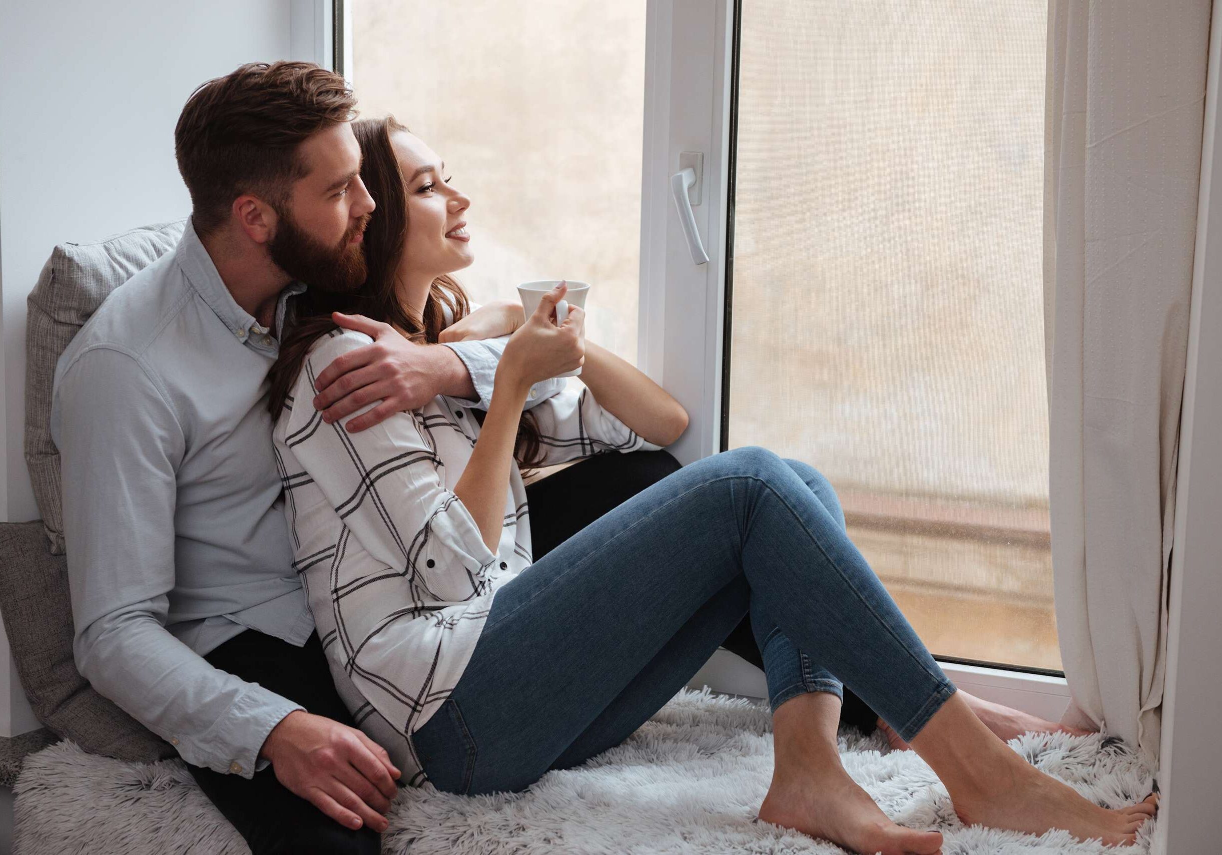 Loving Couple Sitting Together And Look At Window. Girl Drinking Online Marriage and Couples Therapy Overland Park Ks